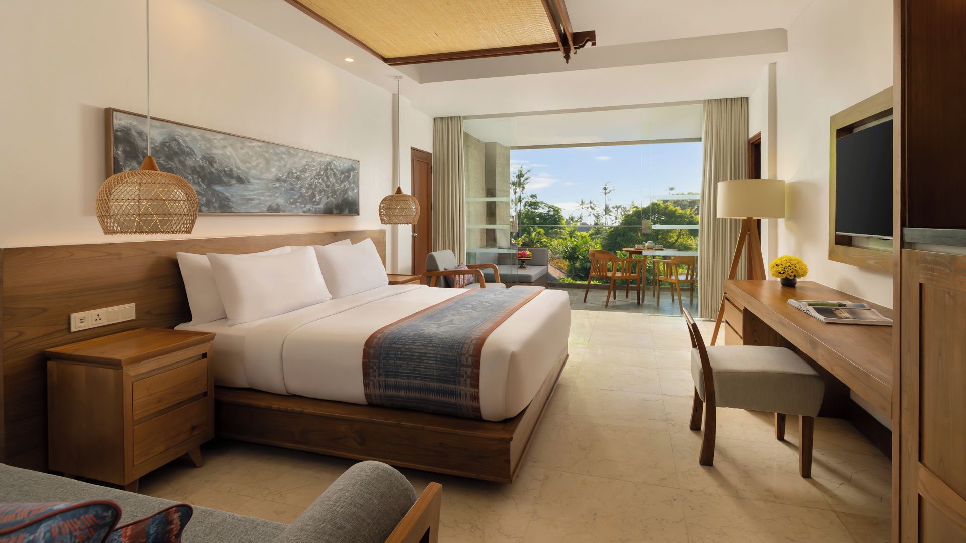A modern hotel room with a large bed, a desk, and a balcony with a view.