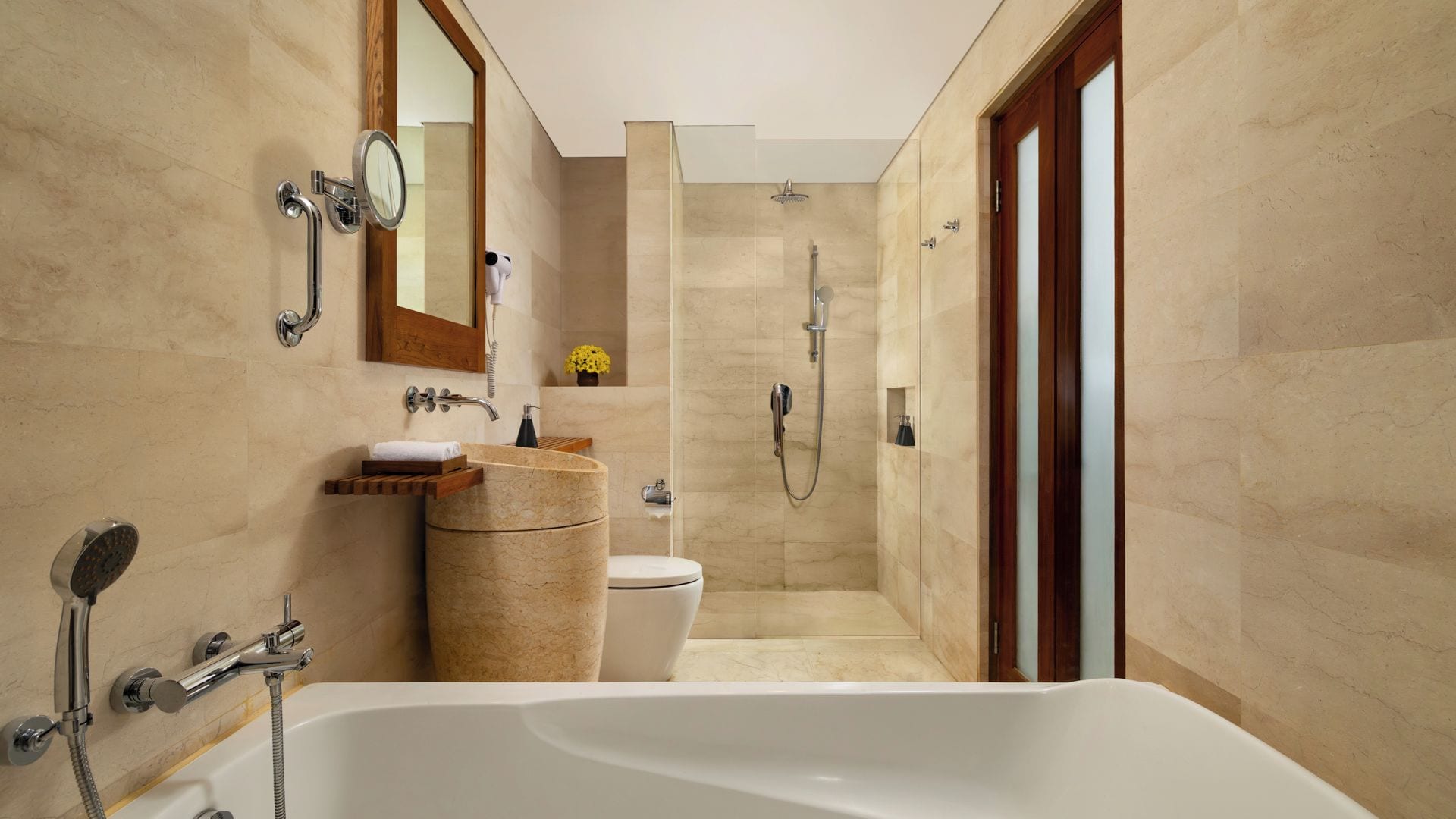 Une salle de bain moderne équipée d’une baignoire, de toilettes, d’une douche et d’un meuble-lavabo avec un miroir.