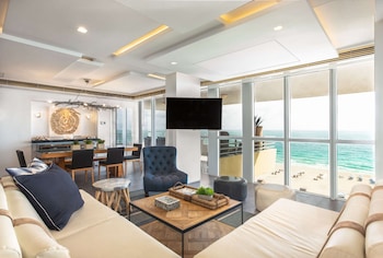 A resort with a pool, beach, and palm trees. at Hilton Bentley Miami/South Beach