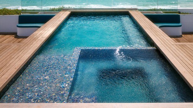 A pool with a view of the ocean and a clear sky. - Hilton Bentley Miami/South Beach (Miami Beach)