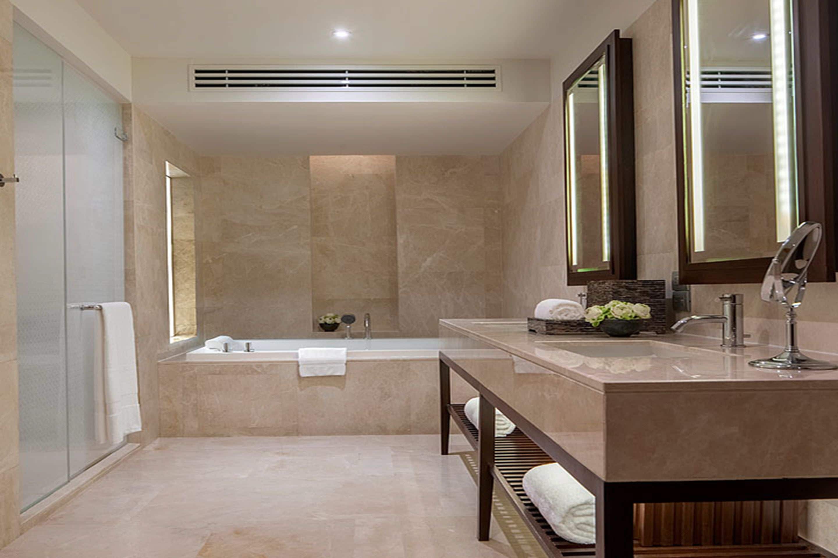 Un baño moderno con bañera, tocador con espejo y zona de ducha.