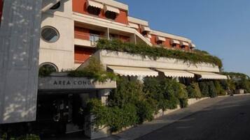 A multi-story building with a flat roof, a sign reading "AREA CONGRESS," and a paved sidewalk.