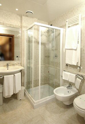 Enjoy a refreshing shower in the bathroom, featuring a glass-enclosed shower area, a standalone sink, and a bidet.