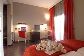 Relax in this stylish room with a large bed, desk, and dining area, perfect for enjoying a meal or working in comfort.