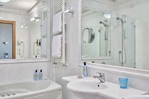 Un bagno moderno con vasca, due lavabi, box doccia in vetro e uno specchio grande.