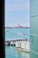 Vista del Gran Canal de Venecia con barcos y un edificio histórico al fondo.