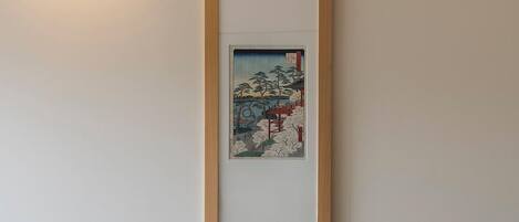 Una sala de estar moderna con un sofá gris, una silla de madera y una obra de arte enmarcada en la pared.