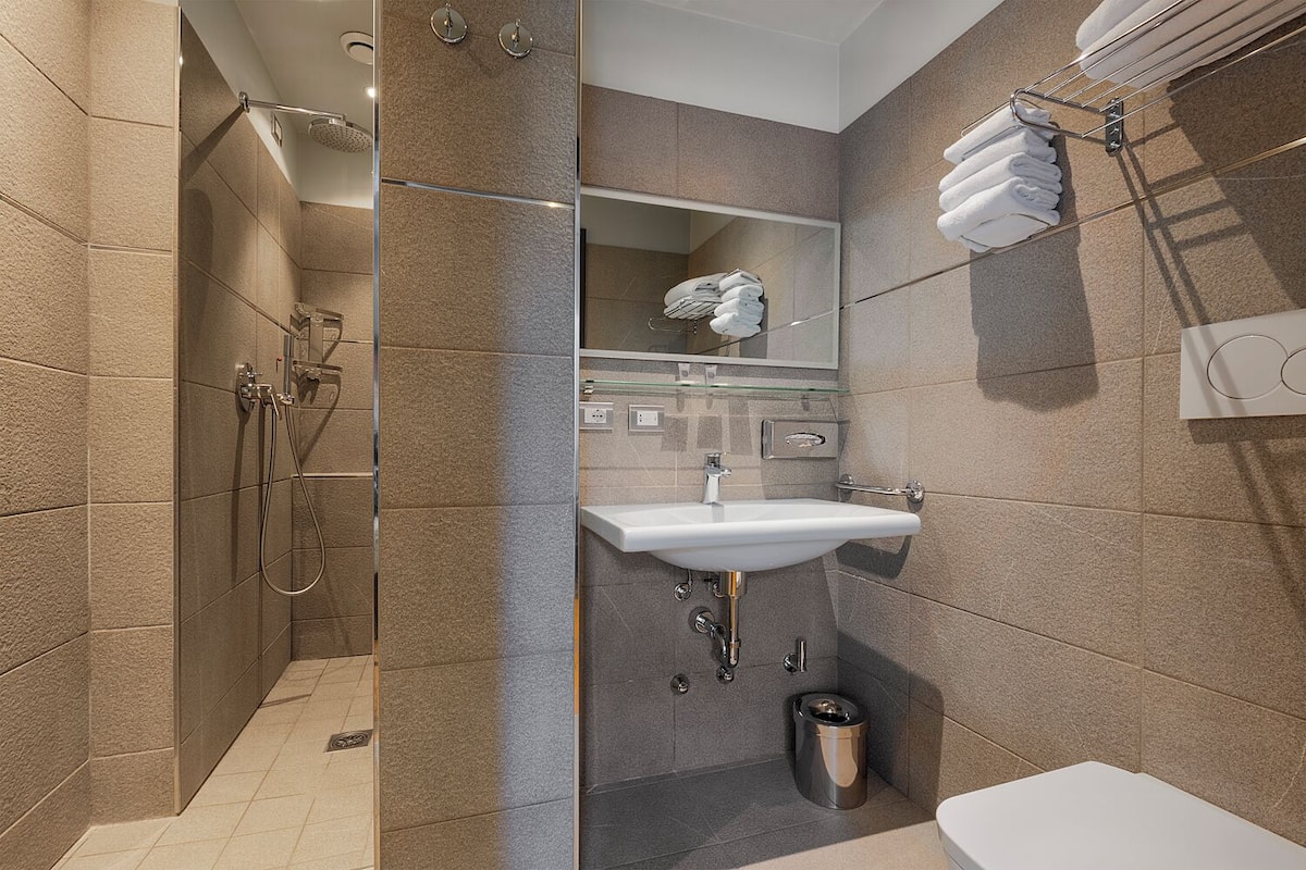 A modern bathroom with a walk-in shower, a sink, and a toilet.