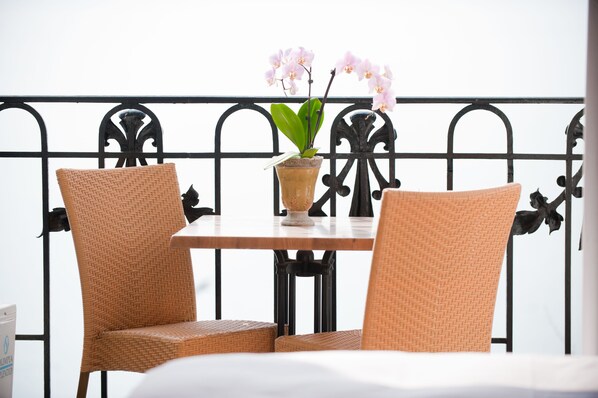 A balcony with wicker chairs, a table, and a potted orchid. - Hôtel du Grand Lac Excelsior (Montreux)