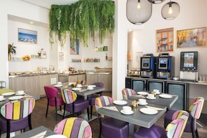 L’intérieur d’un restaurant, avec des tables dressées pour le service, un coin bar et un appareil à café.