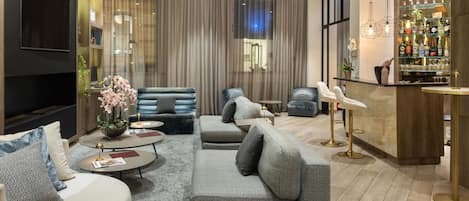 Una sala de estar moderna con zona de bar, que incluye sofás, una mesa de centro y un bar repleto de botellas.