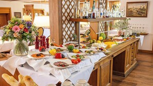 Un buffet proposant divers plats, agrémenté d’une composition florale et offrant un choix de boissons.