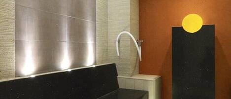 Un baño moderno con una bañera negra, un lavabo blanco y una zona de ducha.
