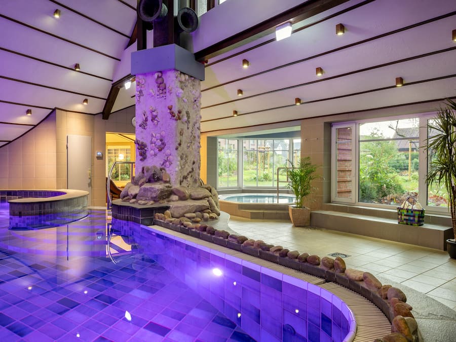 Una piscina techada, sillones reclinables de piscina