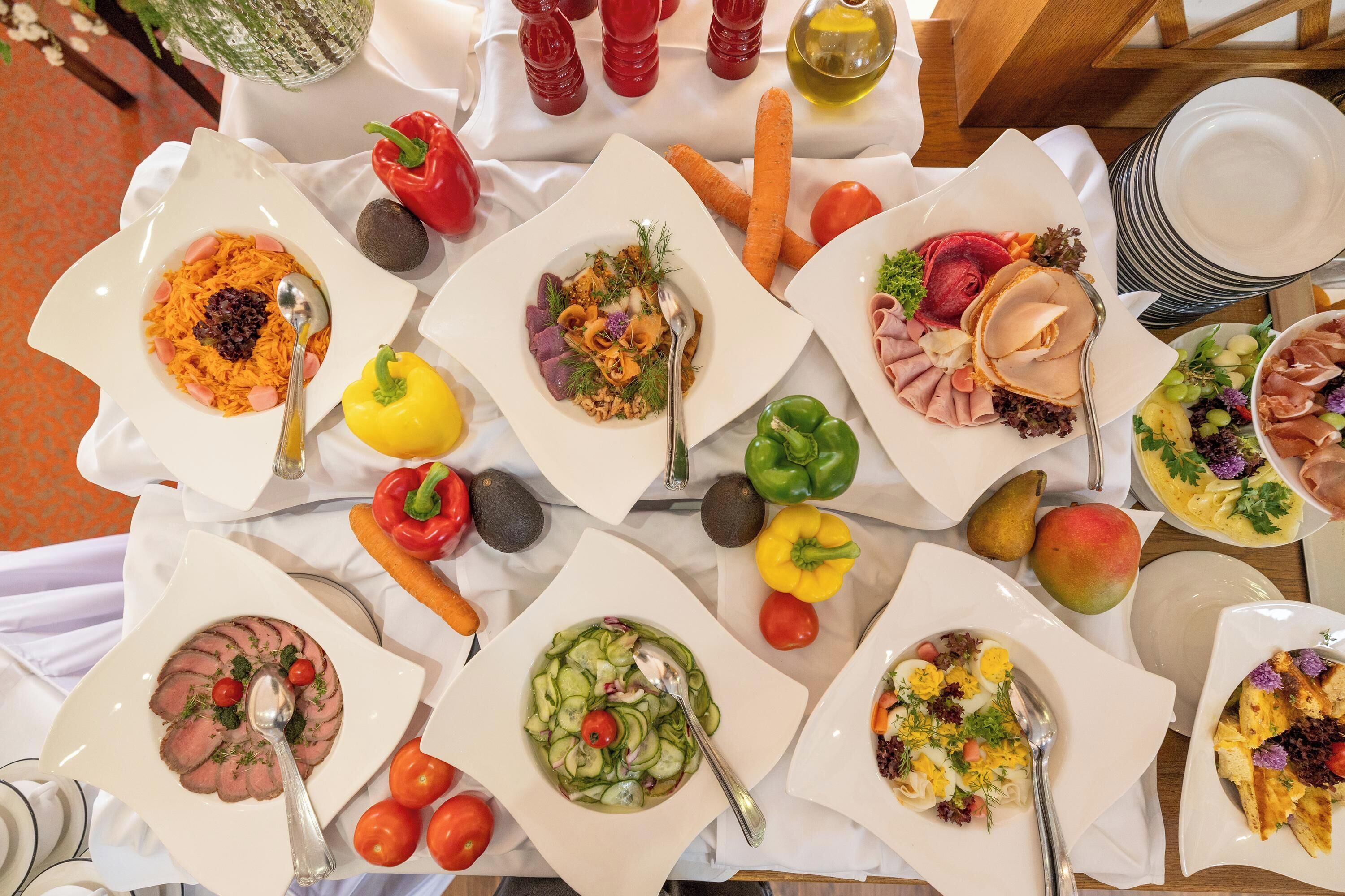 Une table garnie de différents plats, de légumes et de condiments.