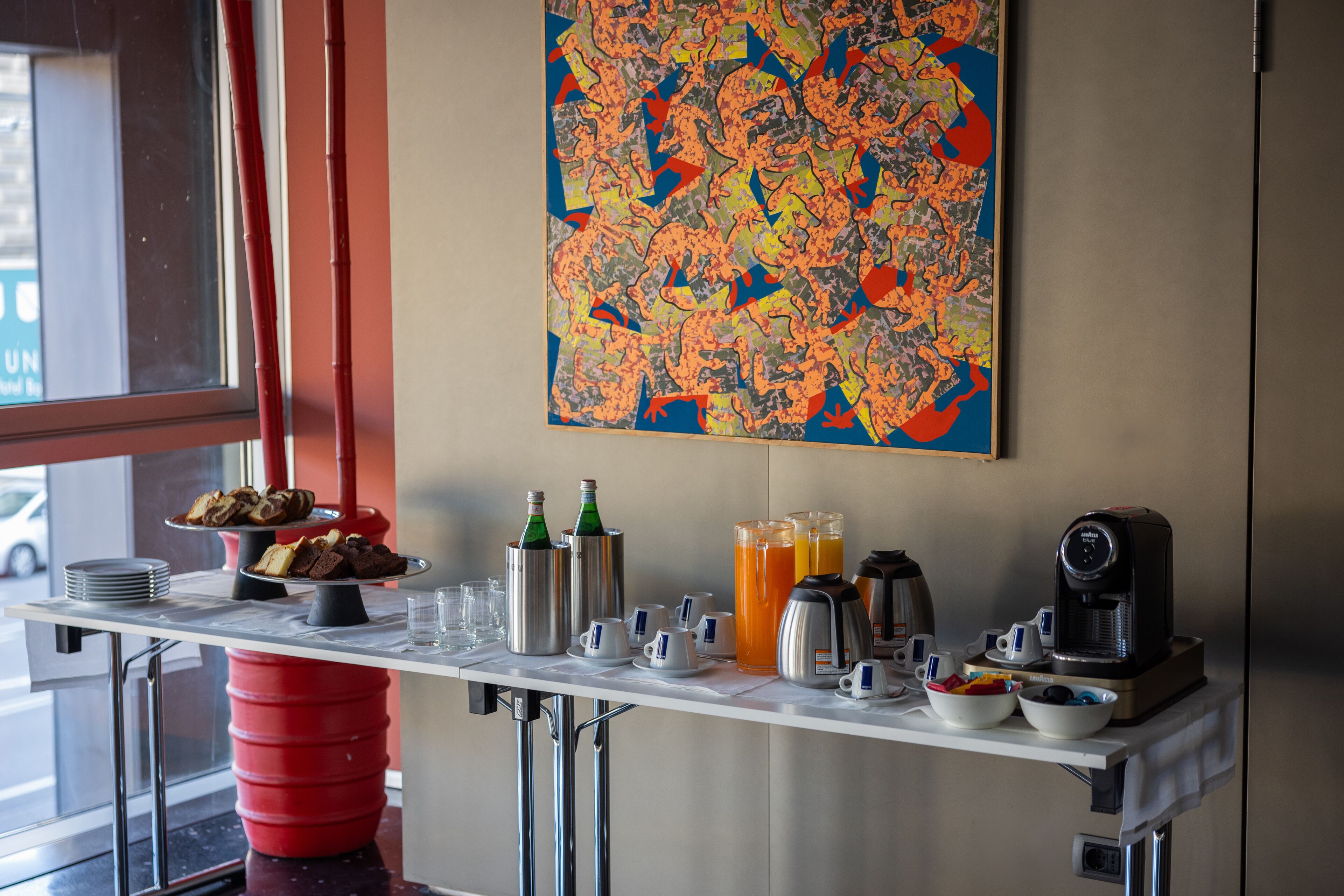 A breakfast bar with coffee machines, a coffee pot, and a fruit bowl.
