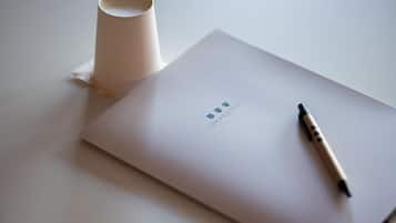 A white envelope with a pen and a rolled-up paper on a table.