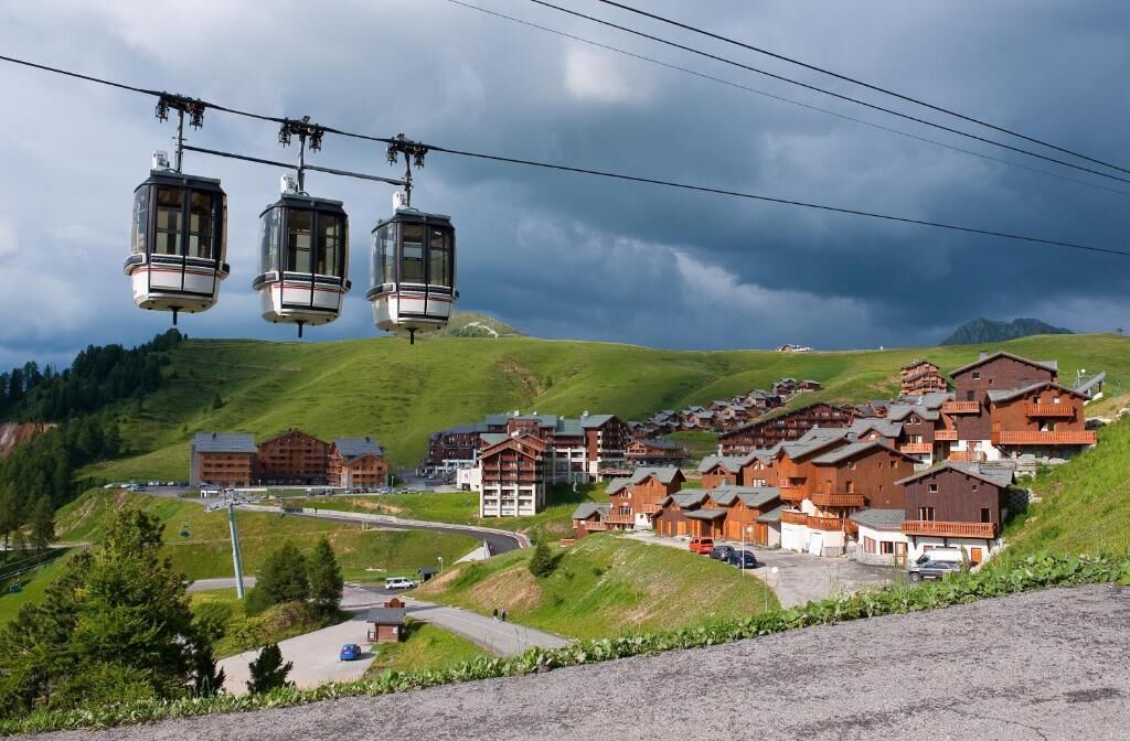 Ein Bergurlaubsort mit Seilbahnen, Chalets und einem Skilift.