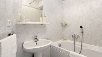 Un baño con lavabo, espejo y bañera.