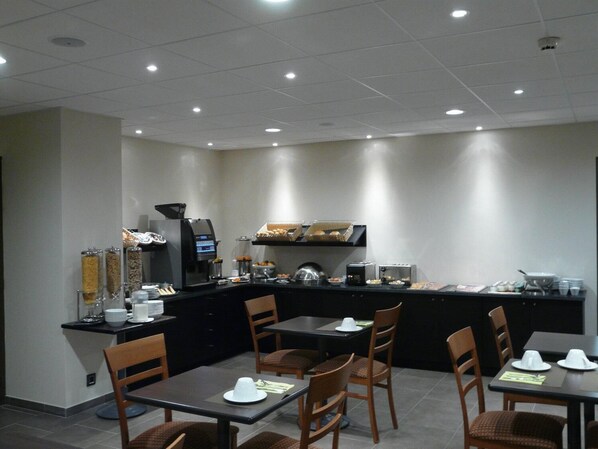 A modern breakfast area with a coffee machine, buffet counter, and seating for guests.