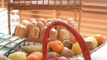 Una exhibición de pan, frutas y huevos sobre una mesa.