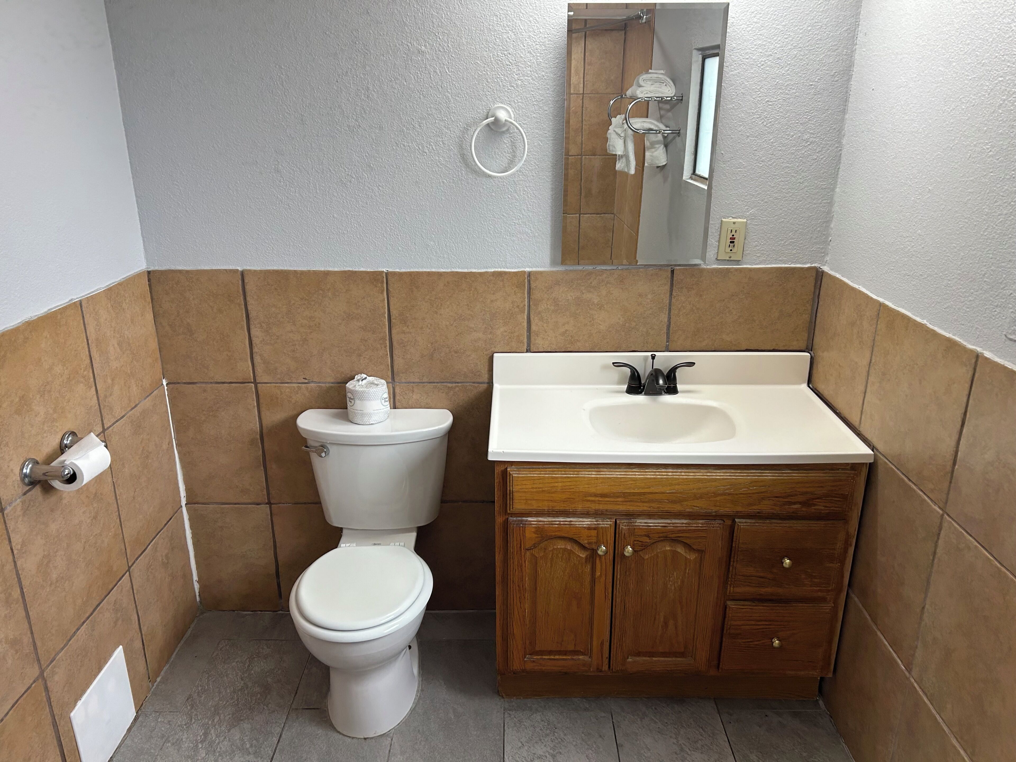 Une salle de bain avec des toilettes, un lavabo et un meuble en bois.