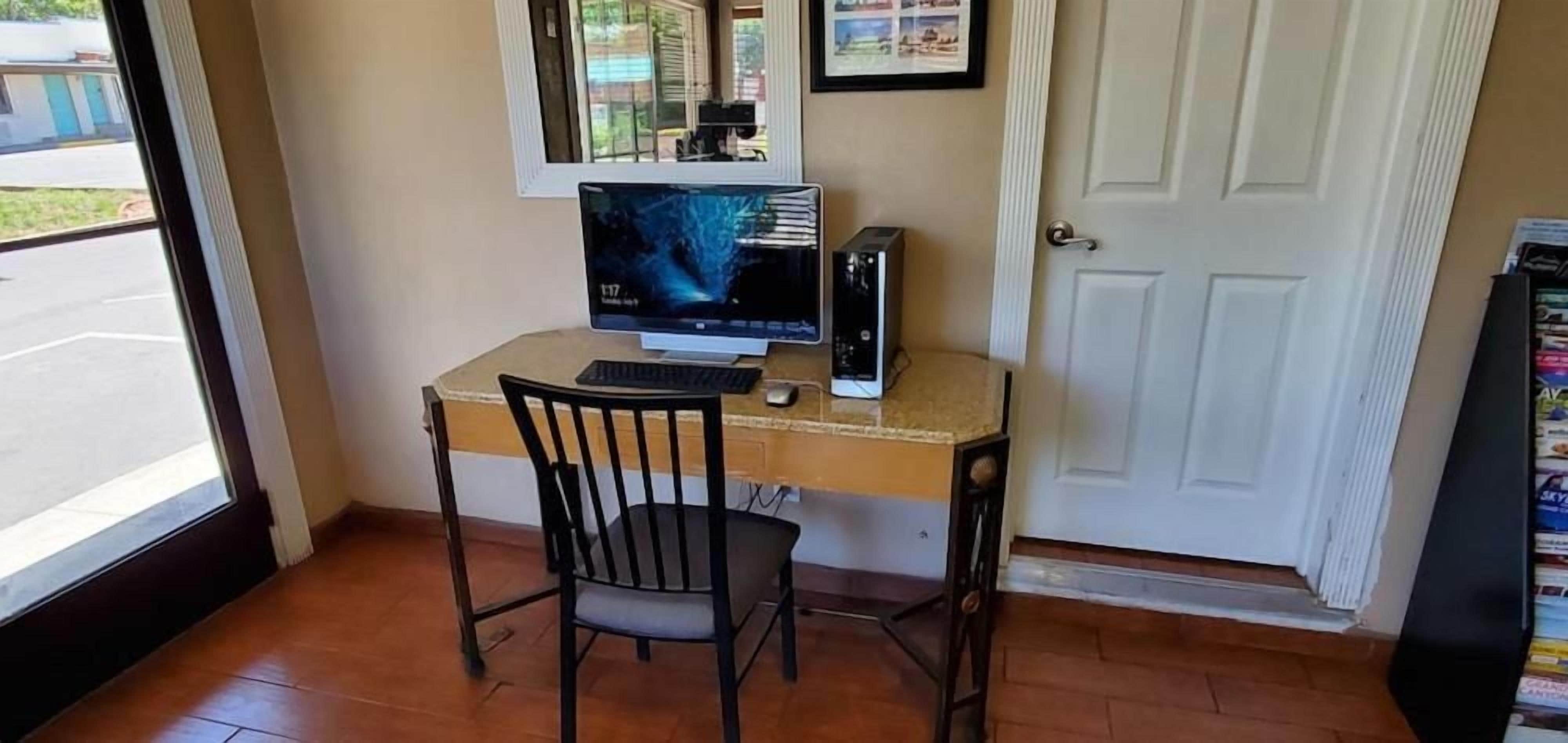 Un pequeño espacio de oficina con un escritorio, computadora y silla.