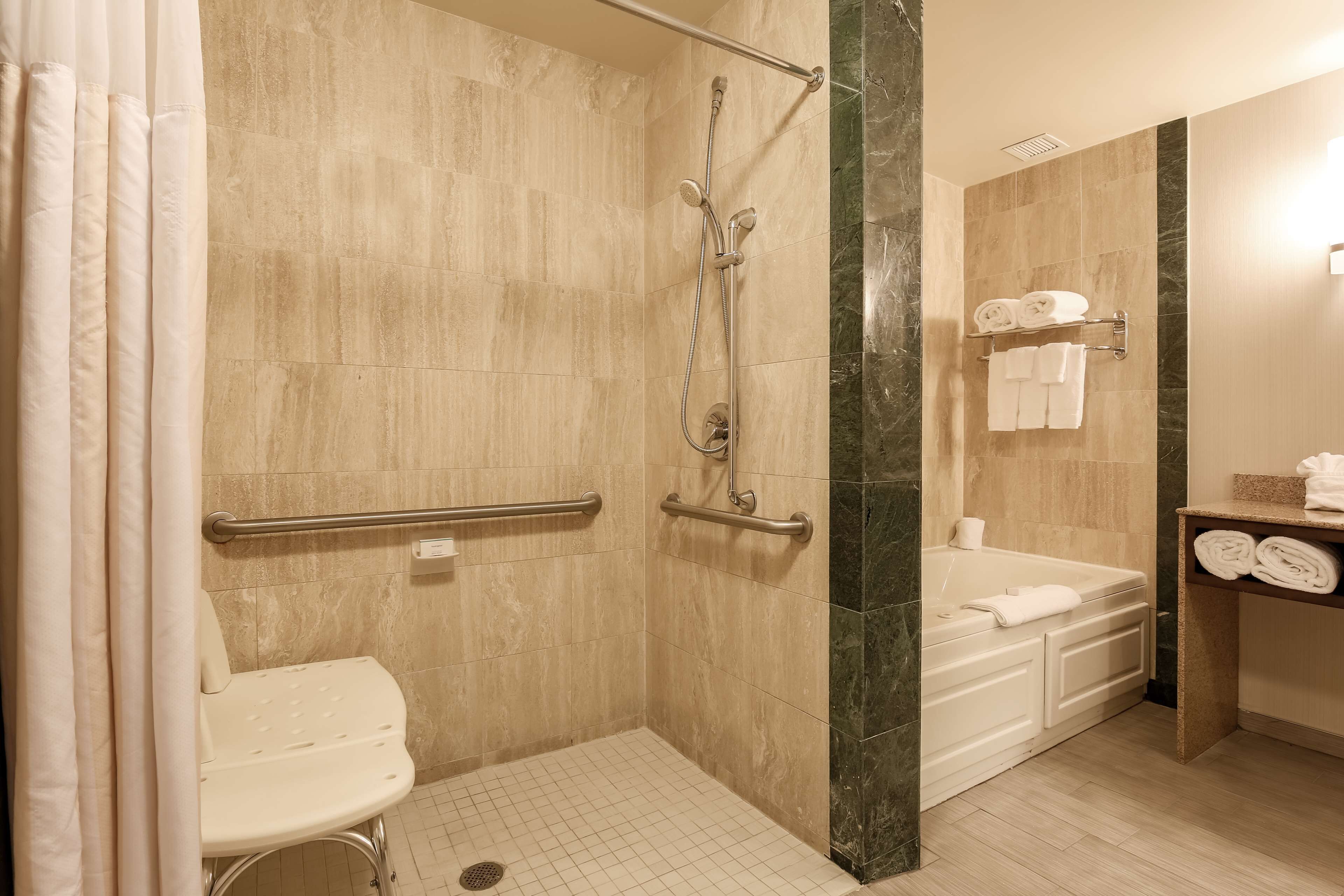 Une salle de bain avec douche, toilettes et baignoire.