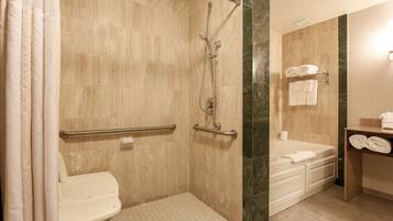 Une salle de bain avec douche, toilettes et baignoire.