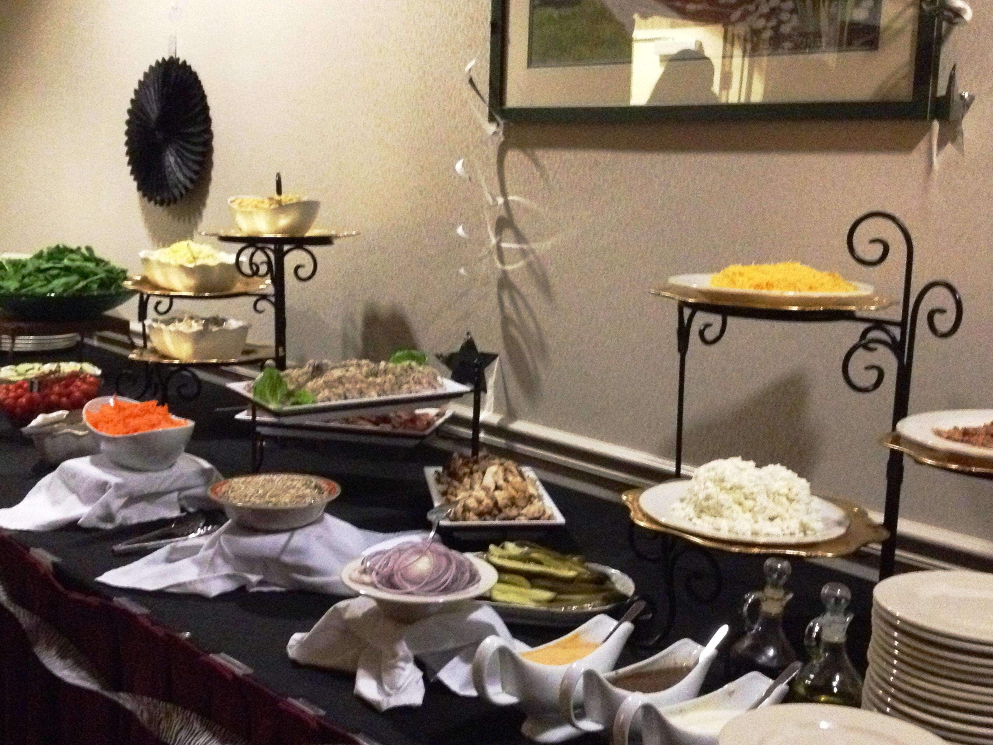 A buffet table with various dishes and condiments.