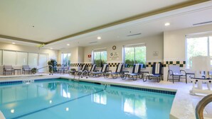 A clean indoor swimming pool with lounge chairs and a lifeguard station. - Hilton Garden Inn Nanuet (Nanuet)