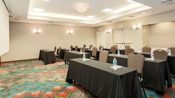 A conference room with tables, chairs, and water bottles.