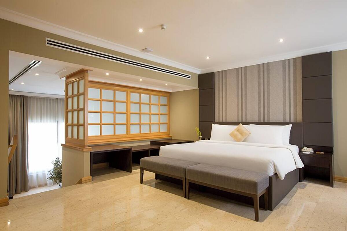 Une chambre d’hôtel moderne avec un grand lit, une armoire en bois et une vue sur l’extérieur.