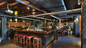A bar area with stools, a bar counter, and a brick wall. - Dubai Marine Beach Resort & Spa (Dubai)