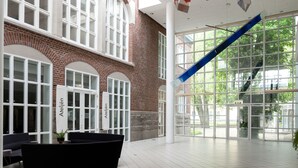 A spacious atrium with a black bathtub, white columns, and a blue staircase. - Elite Park Hotel Växjö (Växjö)