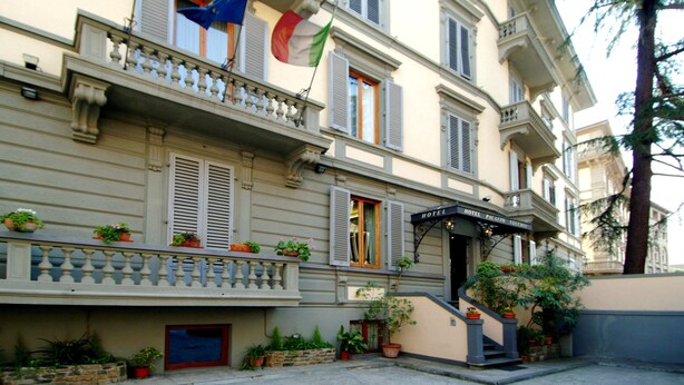 A hotel with a balcony, potted plants, and a staircase leading to the entrance. - Hotel Palazzo Vecchio (Florence)