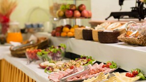 A buffet table with various food items including fruits, cheeses, meats, and salads. - Hotel Palazzo Vecchio (Florence)