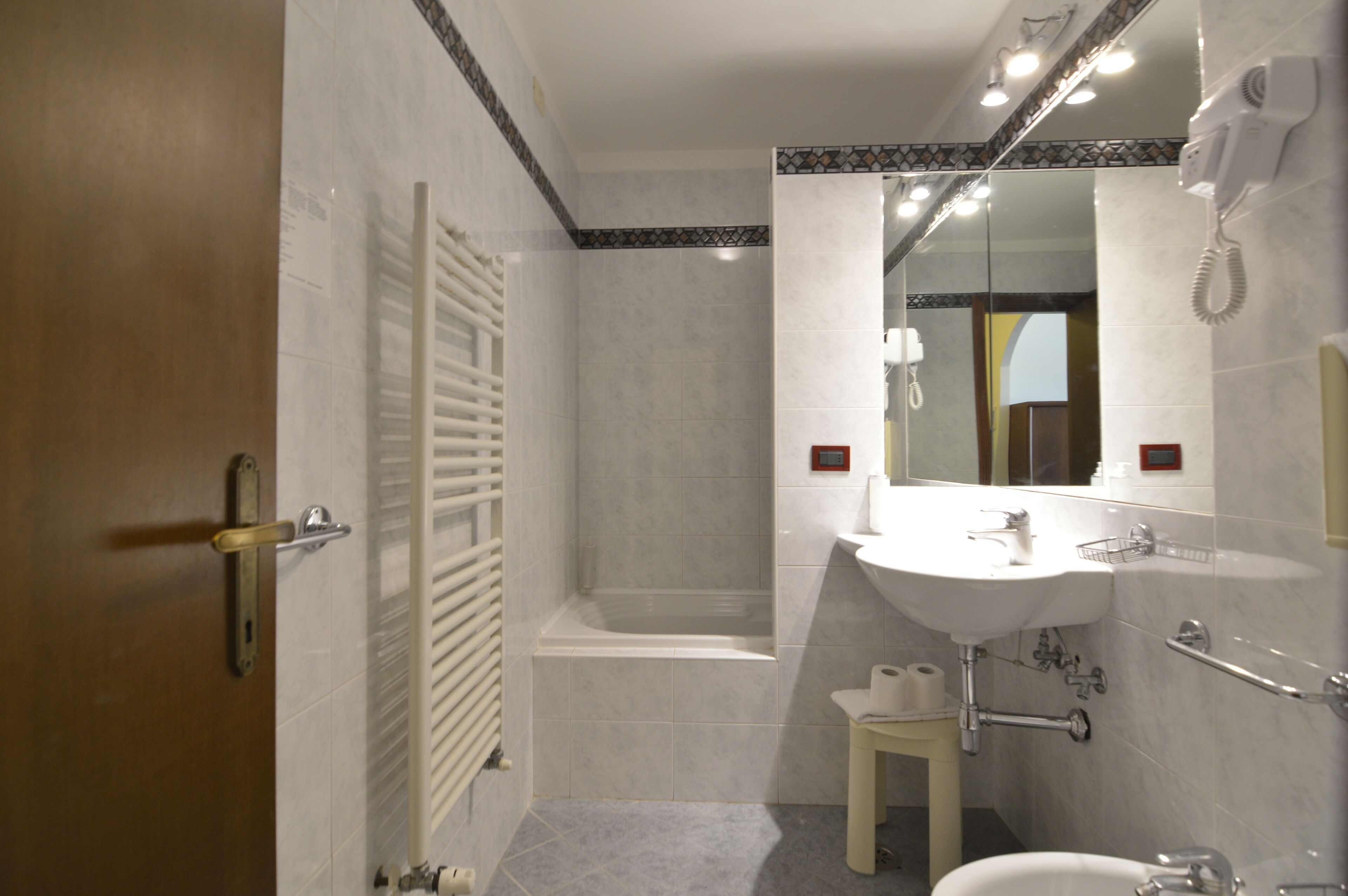 Ein Badezimmer mit Dusche, Toilette, Waschbecken und Spiegel.
