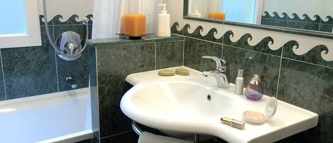Un baño con bañera, lavabo y ducha.