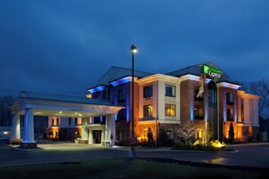 Un hotel Holiday Inn Express con zona de estacionamiento techada y entrada bien iluminada.