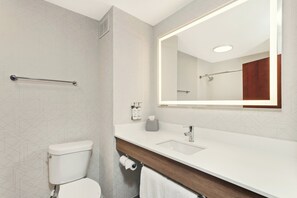 A modern bathroom with a toilet, sink, and mirror. - Holiday Inn Express & Suites North Lima by IHG (North Lima)