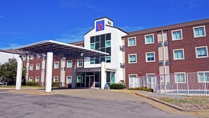 A modern hotel with a covered entrance, multiple windows, and a prominent '6' sign on the building. - Motel 6 West Des Moines, IA (West Des Moines)