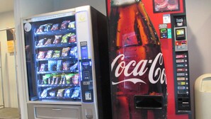 A vending machine with snacks and a Coca-Cola machine. - Motel 6 West Des Moines, IA (West Des Moines)