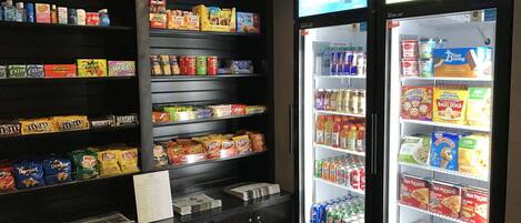 Un espace de vente proposant des collations, des boissons et un réfrigérateur rempli de boissons chaudes et de glaces.