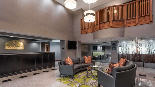 Eine Lobby mit einer Rezeption, zwei Sofas, einem Couchtisch und einem gemusterten Teppich.