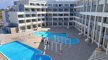 Un hôtel à étages, doté d’une cour intérieure avec une piscine et d’espaces extérieurs aménagés pour se détendre.