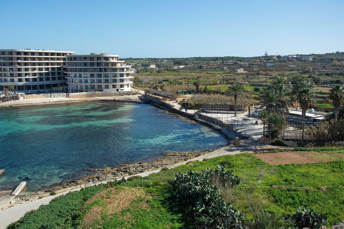 Un hotel costero con varios pisos, un puerto deportivo y vistas del paisaje circundante.