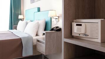 Ein Hotelzimmer mit einem Bett, einem Schreibtisch, einem Telefon und einem digitalen Safe.