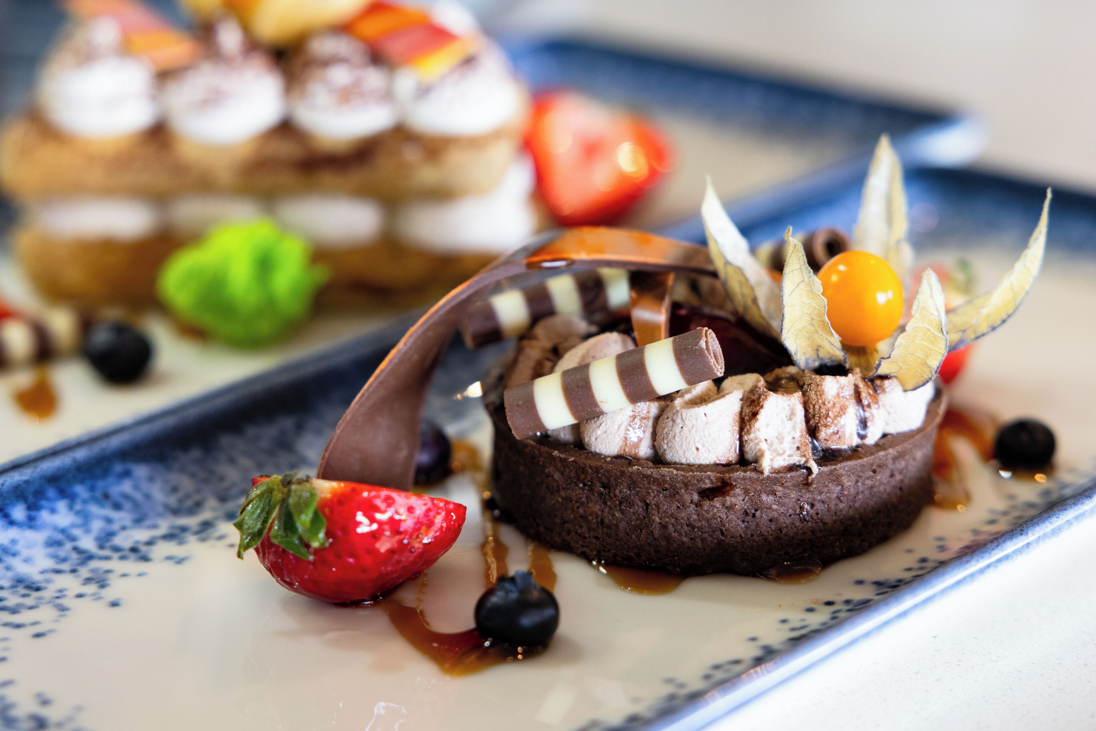 A dessert plate with chocolate cake, strawberries, and blueberries.