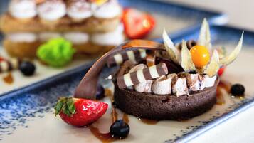 A dessert plate with chocolate cake, strawberries, and blueberries.